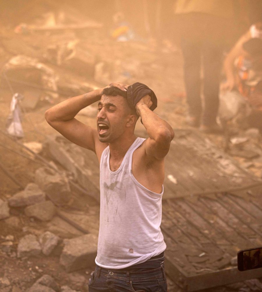 A Palestinian man reacts as others check the rubble of a building in Khan Yunis on November 6, 2023, amid the ongoing battles between Israel and the Palestinian group Hamas. Thousands of civilians, both Palestinians and Israelis, have died since October 7, 2023, after Palestinian Hamas militants based in the Gaza Strip entered southern Israel in an unprecedented attack triggering a war declared by Israel on Hamas with retaliatory bombings on Gaza. (Photo by MAHMUD HAMS / AFP) (Photo by MAHMUD HAMS/AFP via Getty Images)